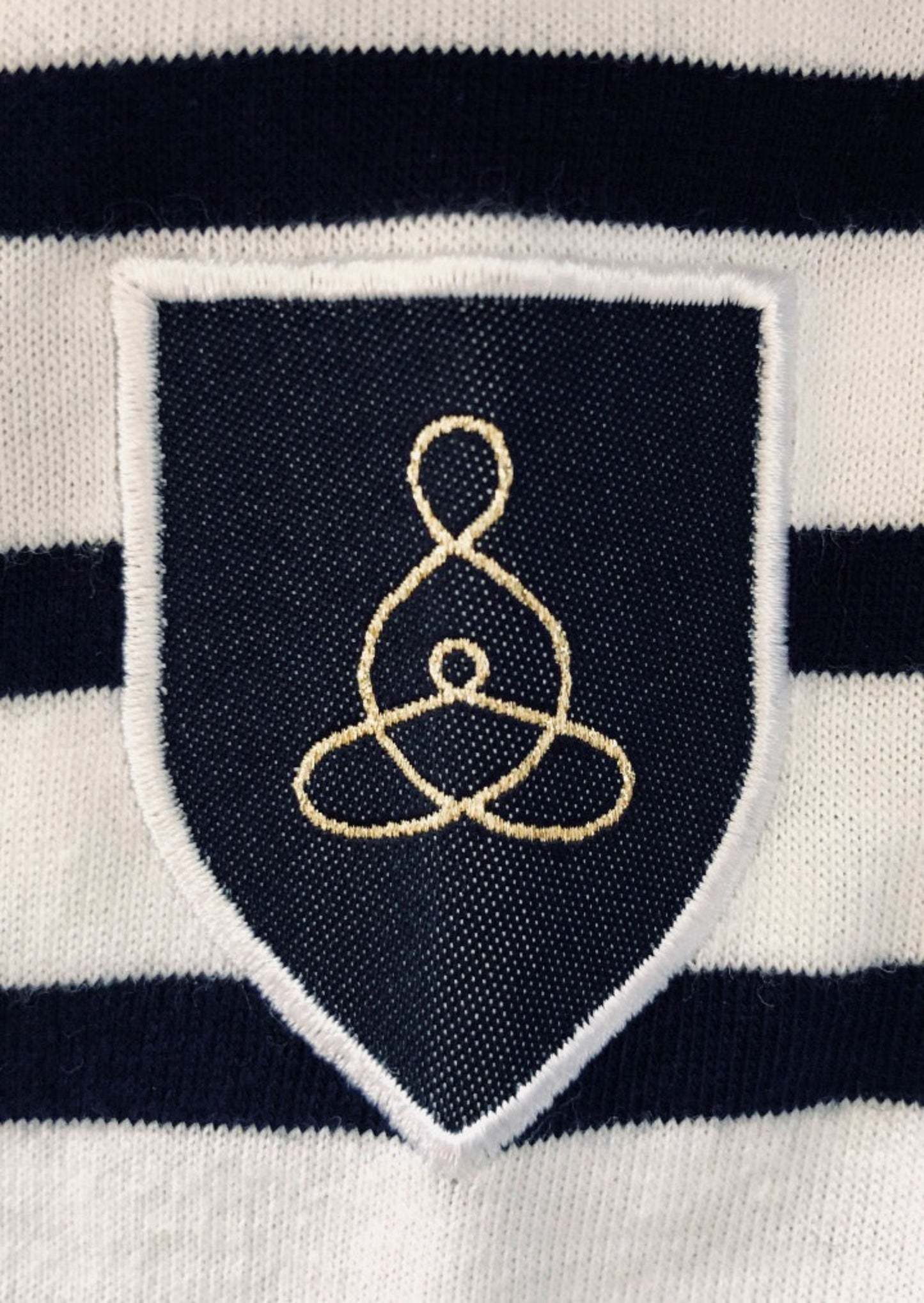 DÉTAIL BLASON TISSÉ SYMBOLE CELTE DE LA MATERNITÉ MÈRE ET ENFANT LIÉS BRODÉ POINT BOURDON SUR MARINIERE UNISEXE ADULTE ET D'EMIE CHAPITRE I LA BRETAGNE